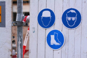 Drei Schilder mit Gebotszeichen auf einer Baustelle.