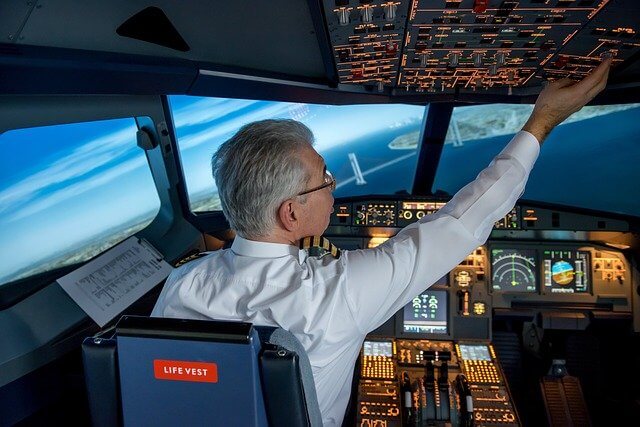 Ein Pilot sitzt mit einer Checkliste im Cockpit